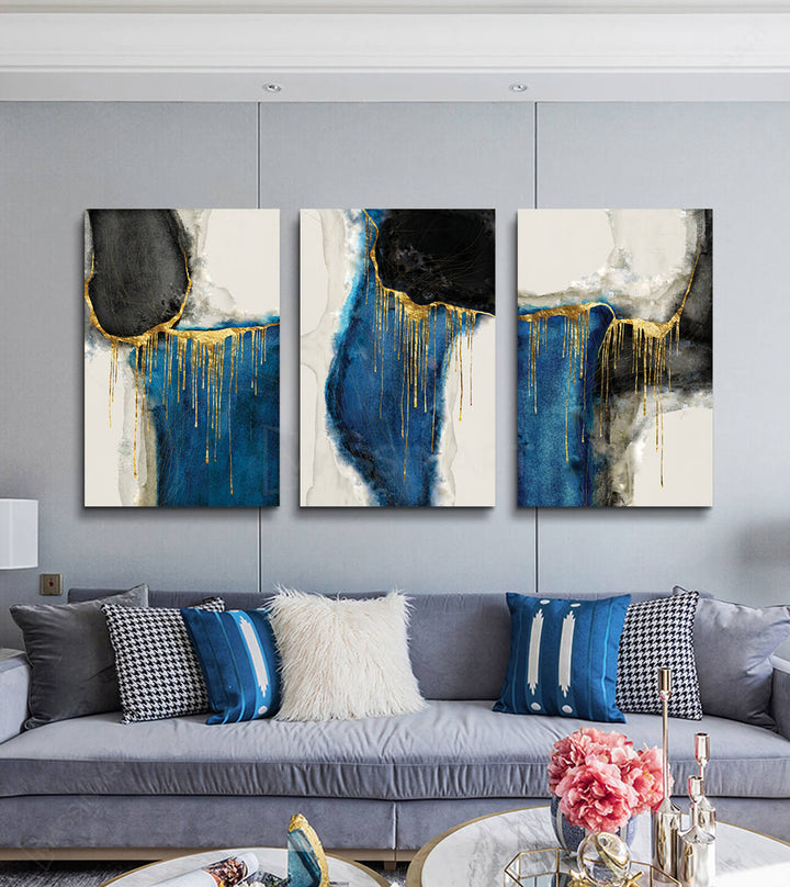Mise en situation salon moderne Massinart — triptyque abstrait bleu or au-dessus canapé beige